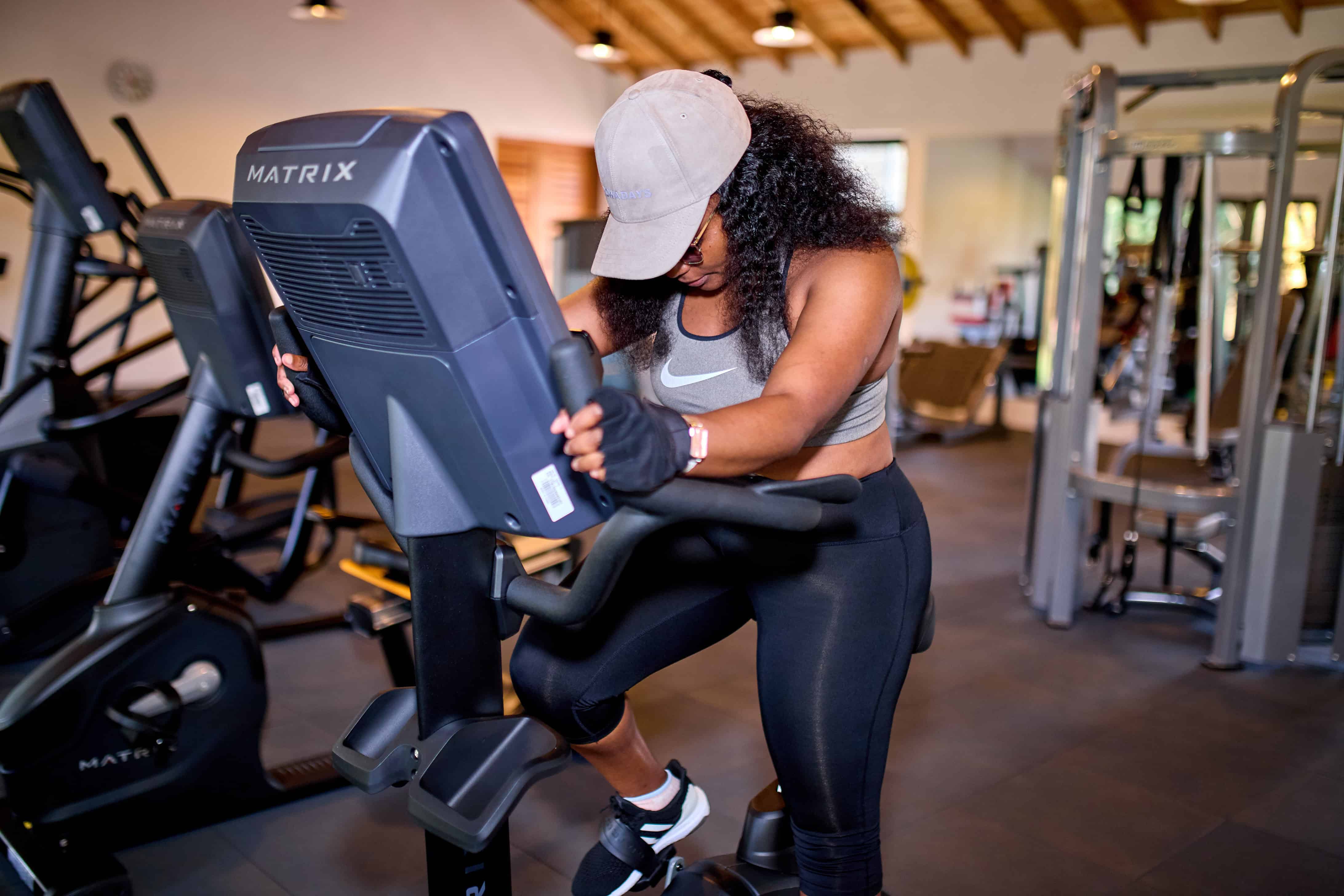 Woman using stationary bike in well-equipped fitness center