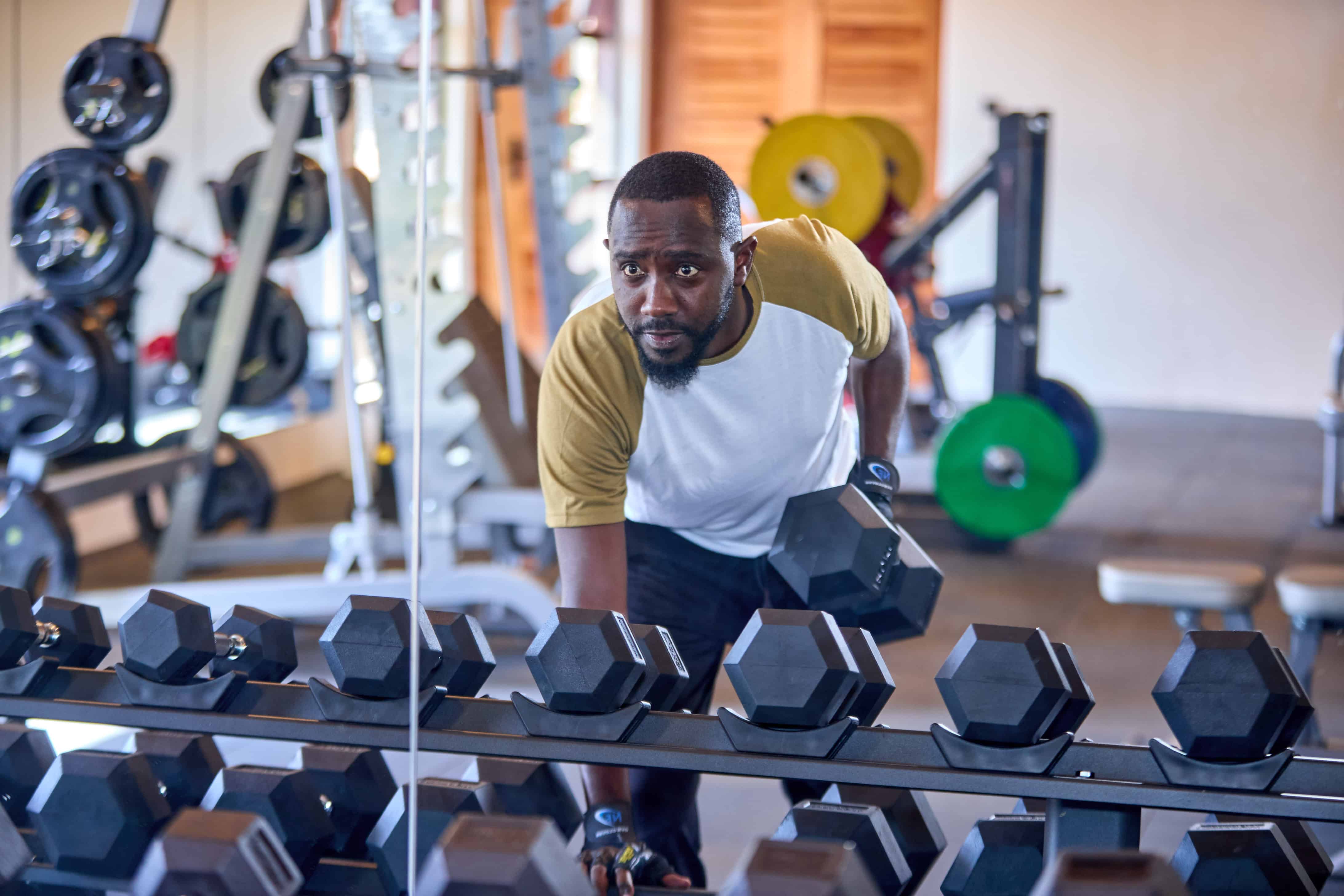 Man working out with dumbbells in modern fitness facility