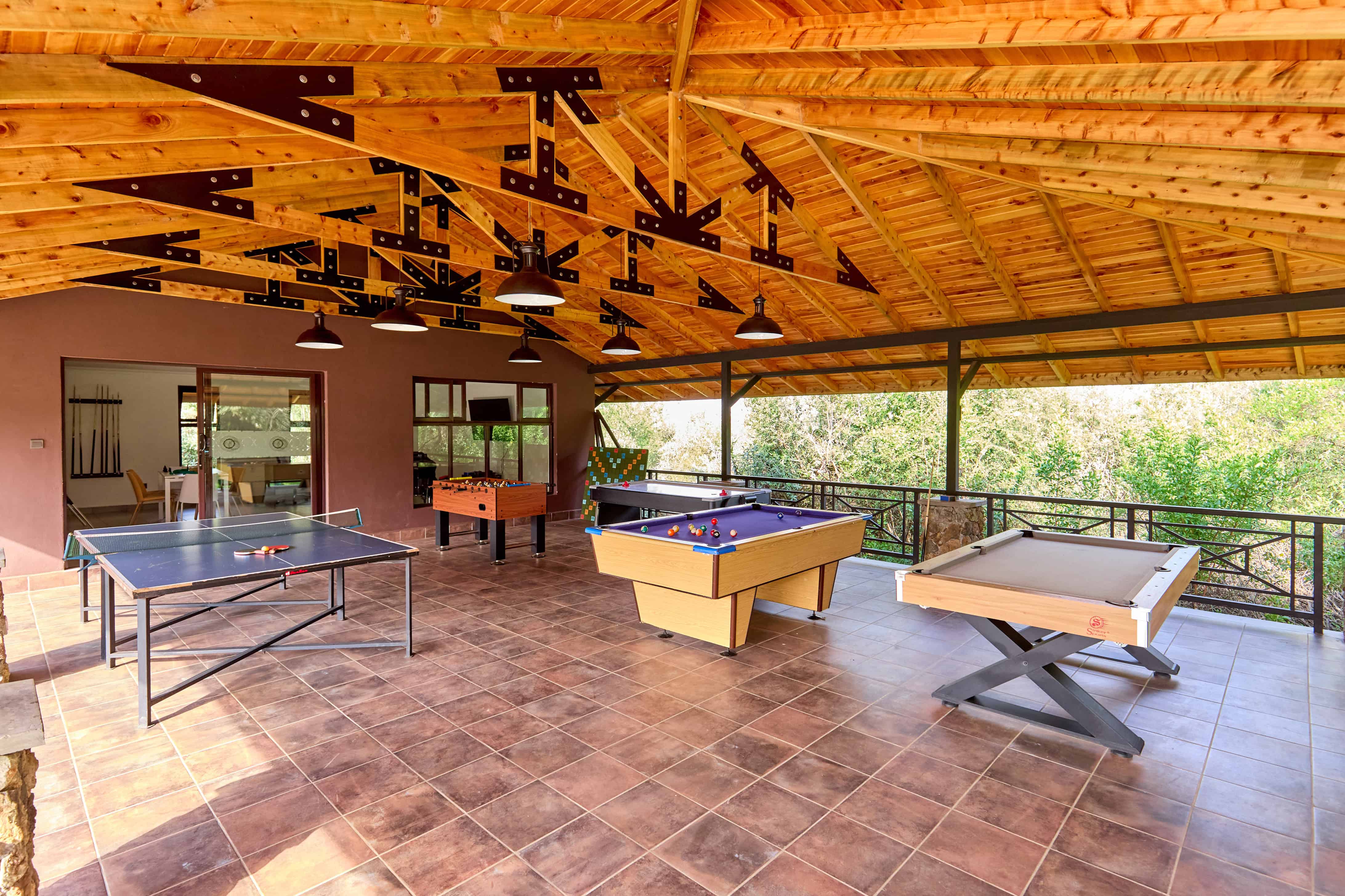 Games room with ping pong, pool table, and foosball under wooden beams