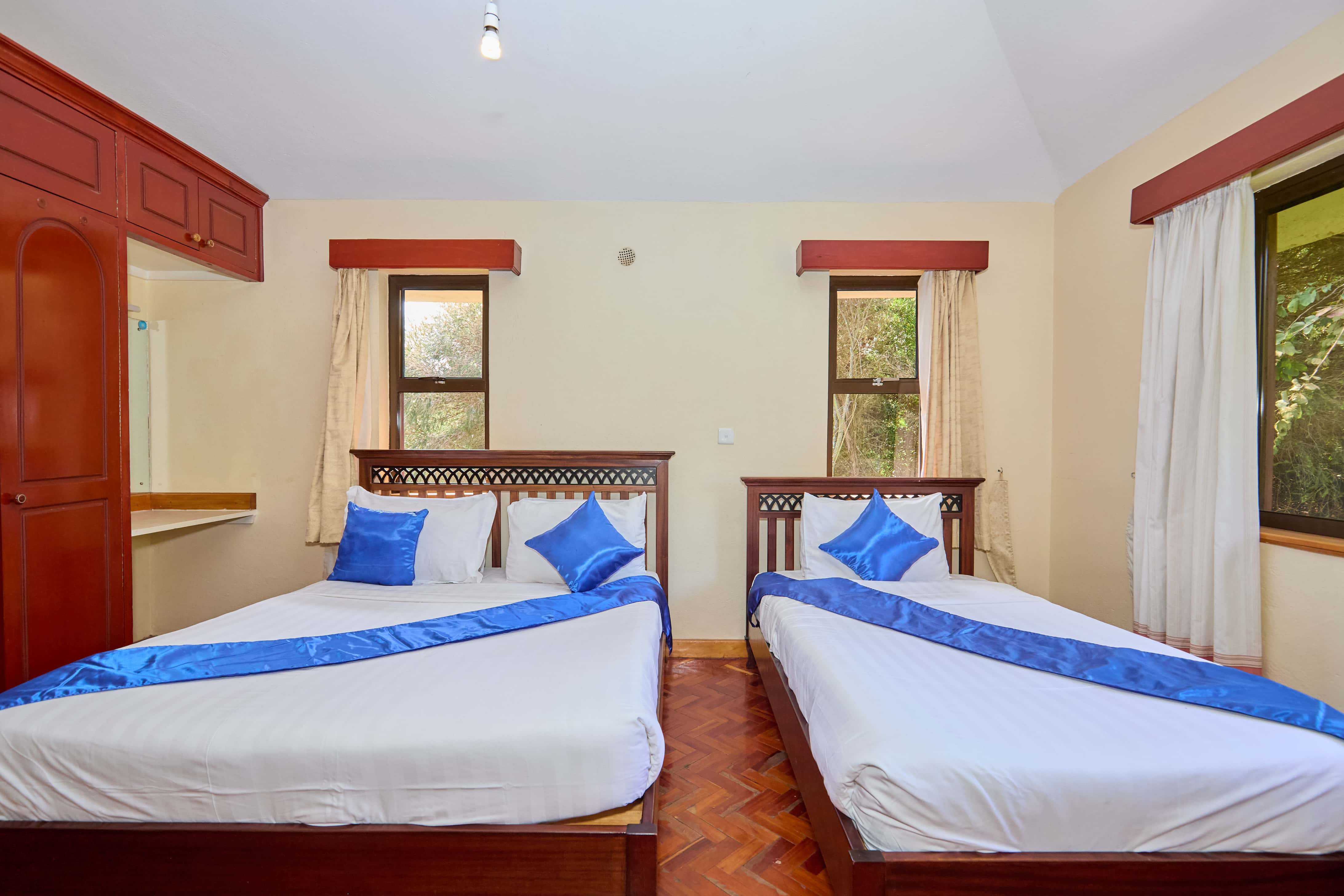 Twin bedroom with blue accents and wooden furniture