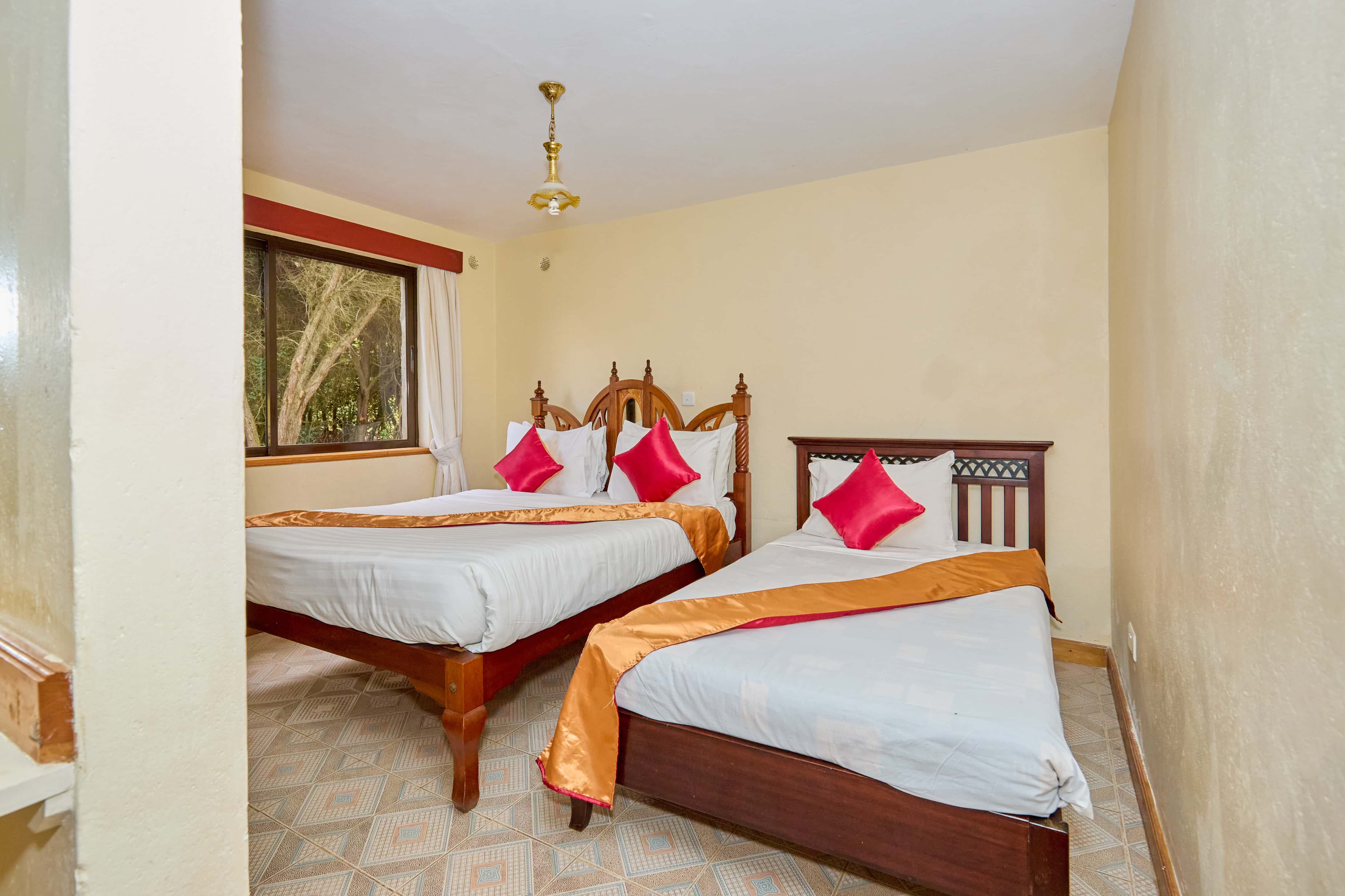 Twin bedroom with decorative headboards and pink accents