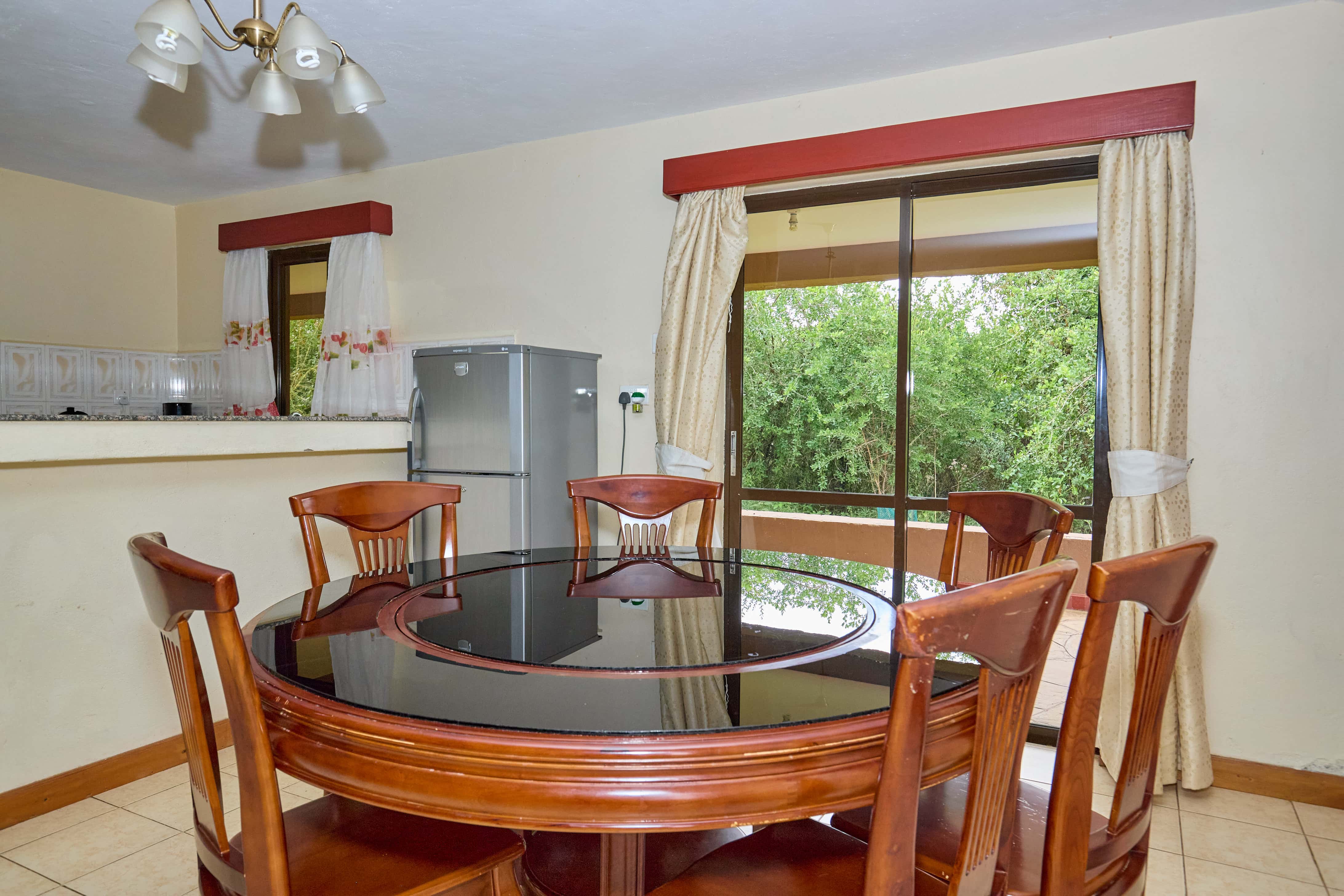 Formal dining area with round glass-top table and wooden chairs