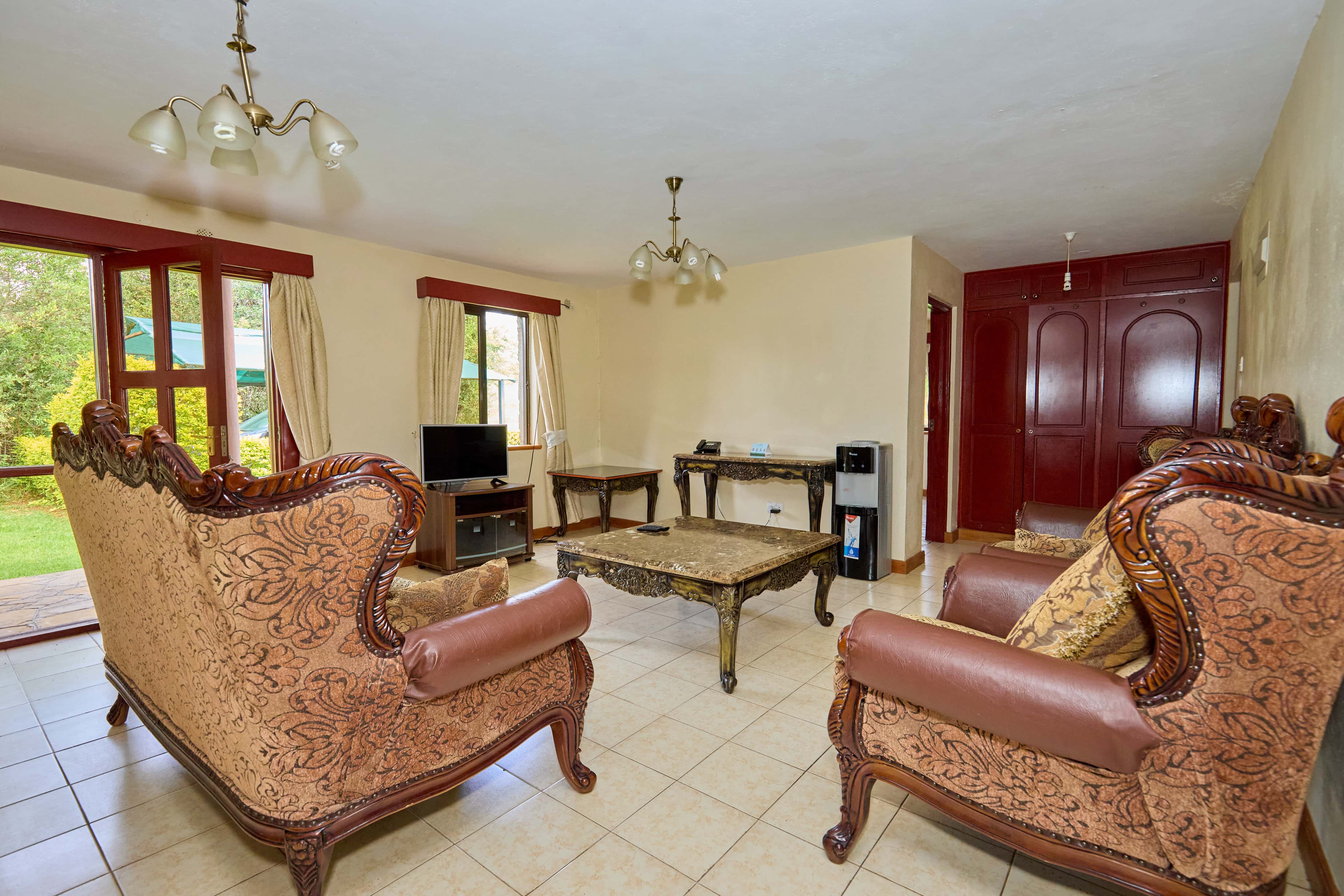 Living room with ornate carved armchairs and built-in wardrobes
