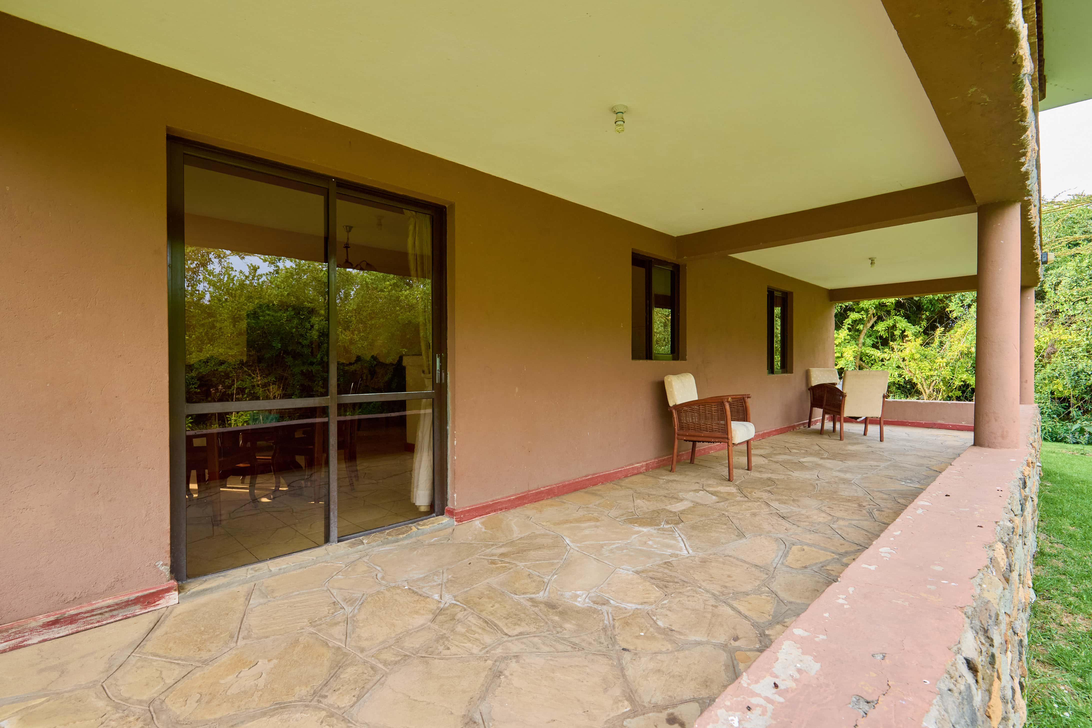 Covered terrace with outdoor seating overlooking gardens