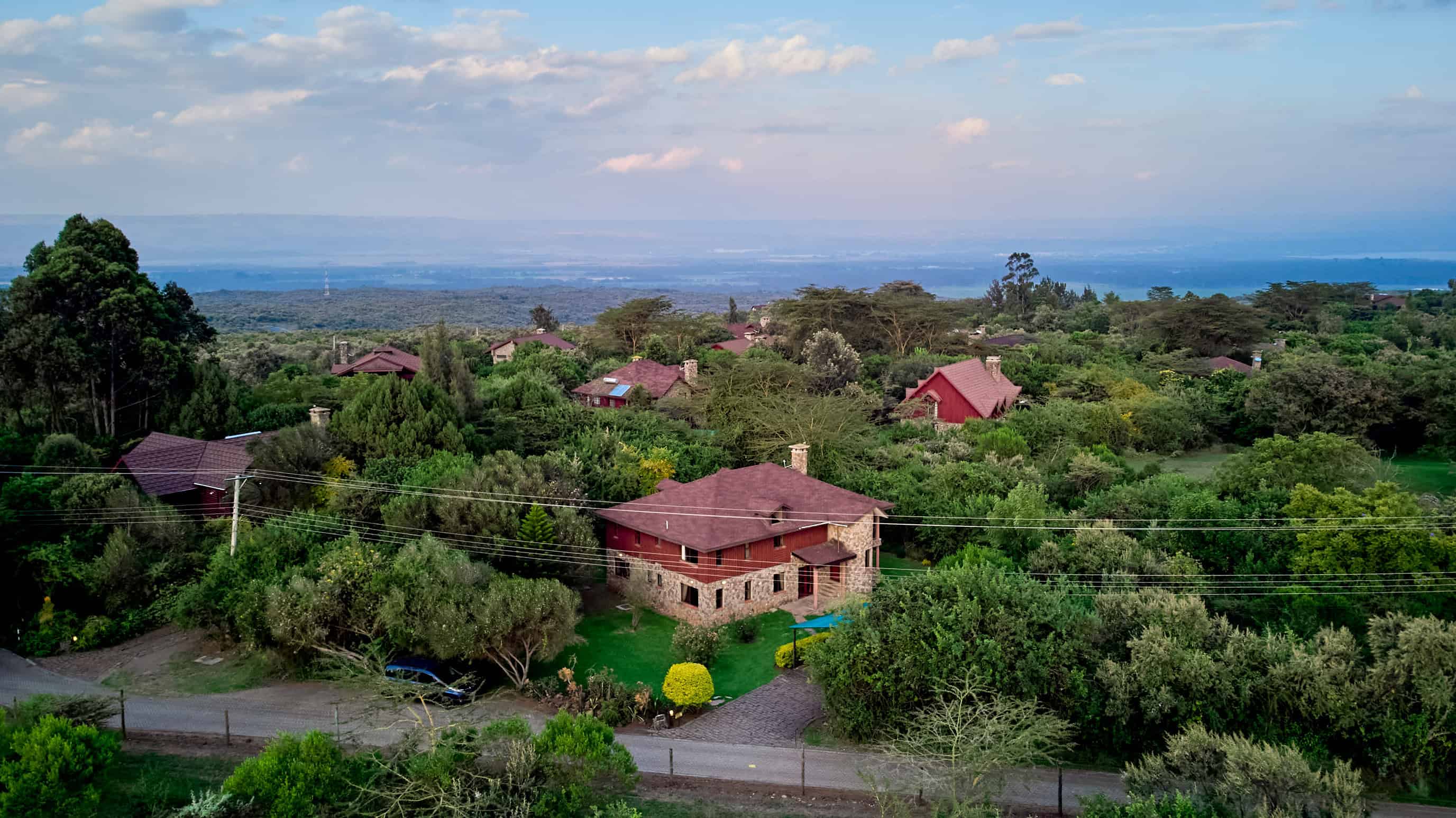 Wide aerial shot of property in natural setting with rolling hills