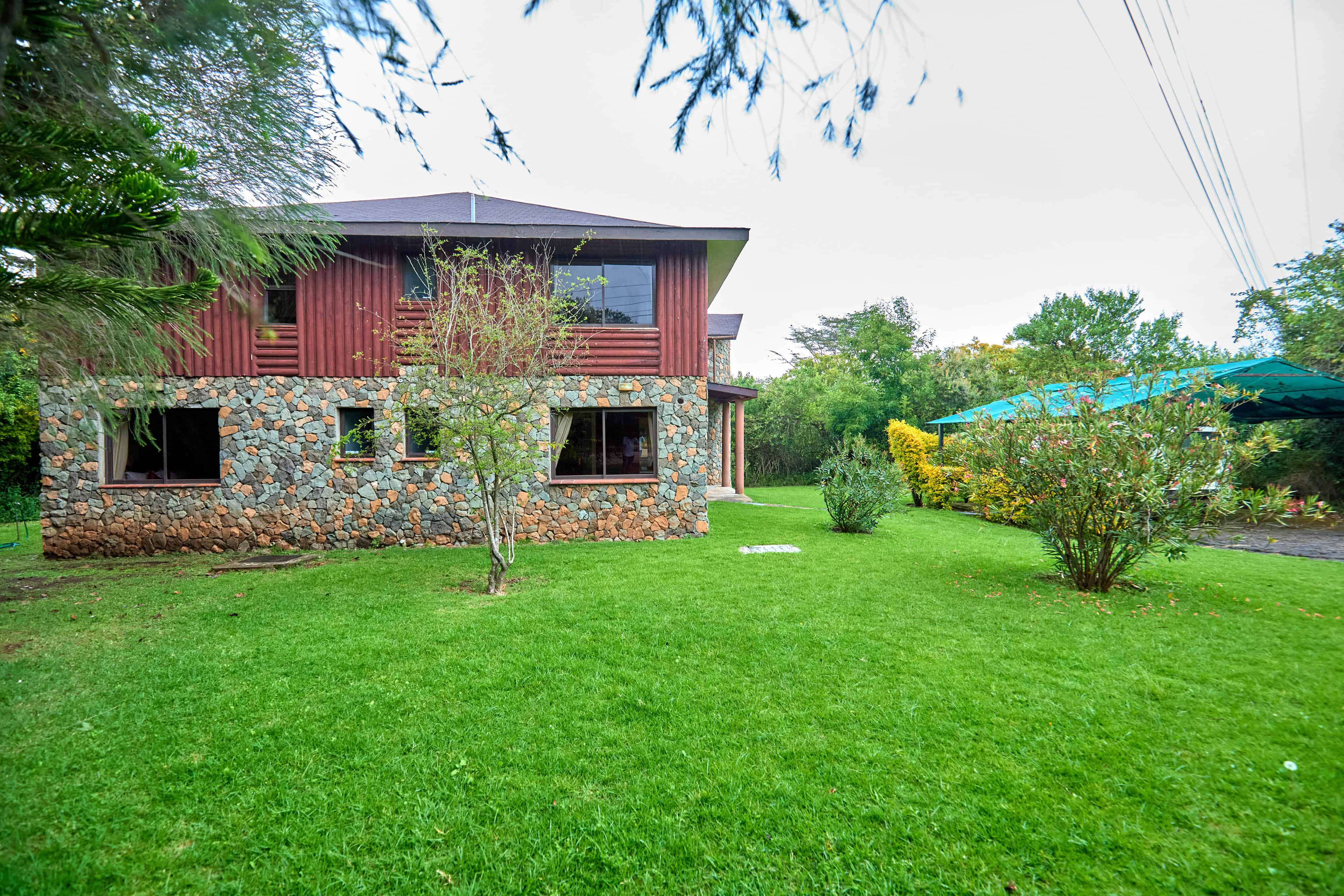 Exterior showing modern stone and wood design with mature landscaping