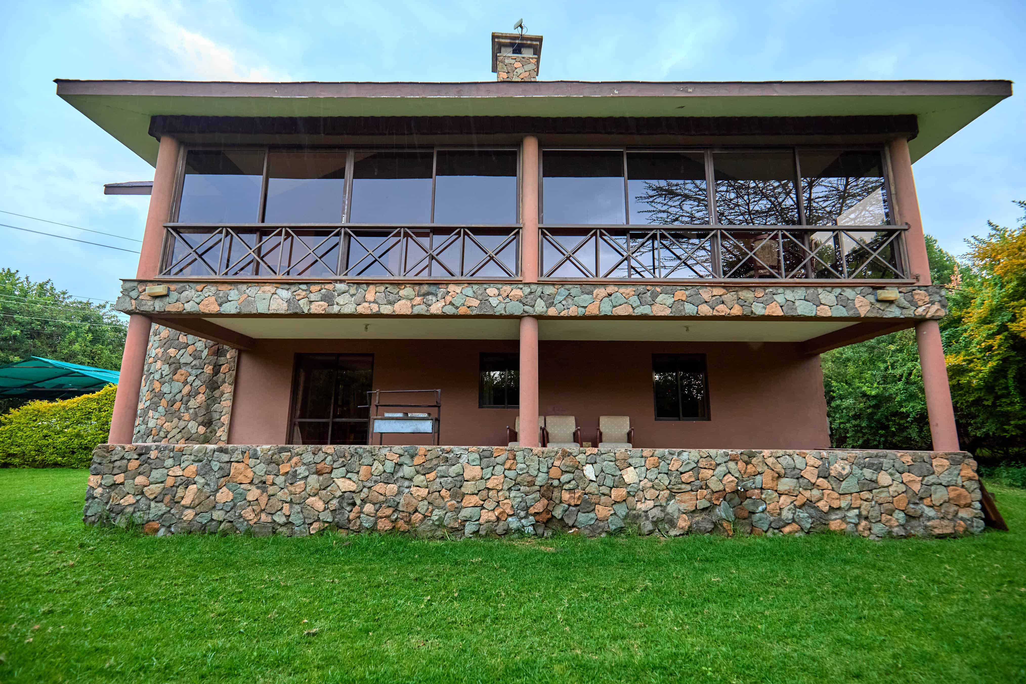 Front view of the main chalet with stone foundation and wooden balcony