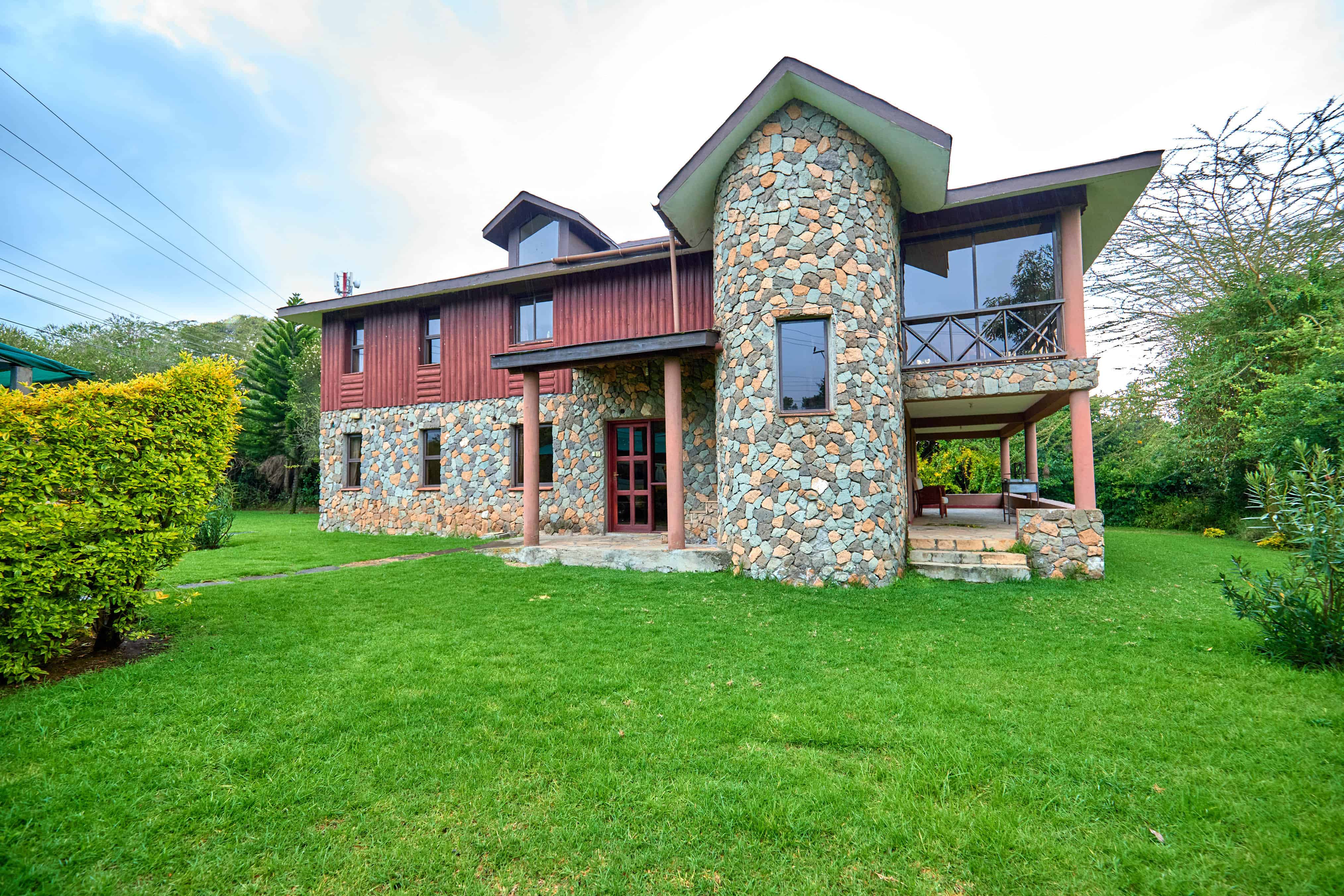 Side angle showing stone work and red wooden siding architecture